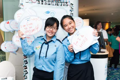 Two girls hold handwritten signs saying, “I am free to be myself”.
