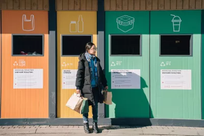 A young girl from Kazakhstan stands thoughtfully in front of colorful recycling bins, ready to make a positive impact