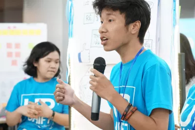  boy speaks into a microphone at an UPSHIFT workshop in Vietnam.