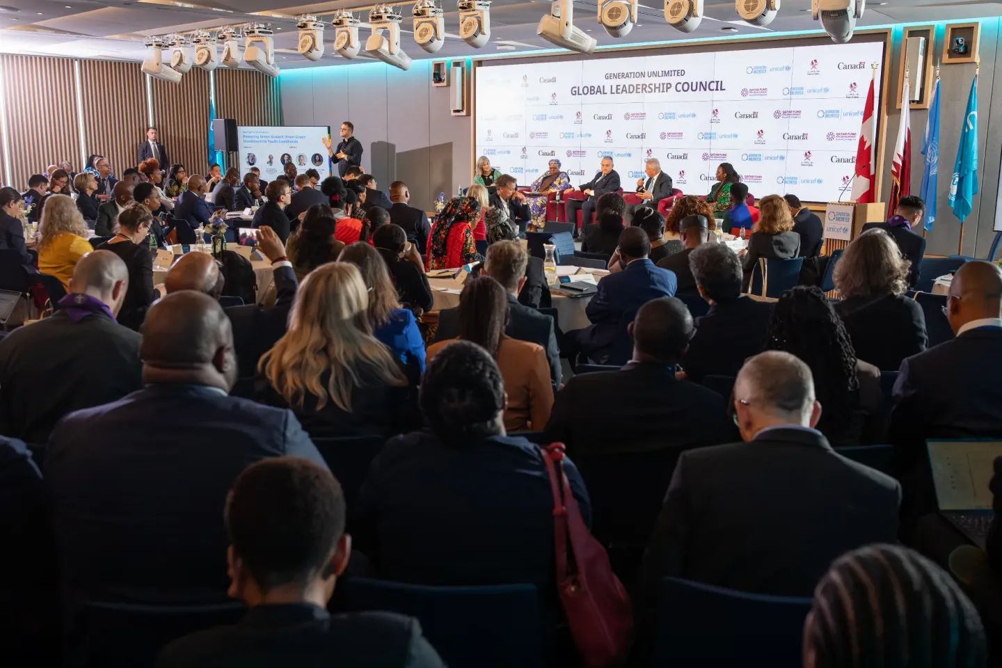 Photo of the global leadership council, showing a panel discussion on stage with attendees seated around