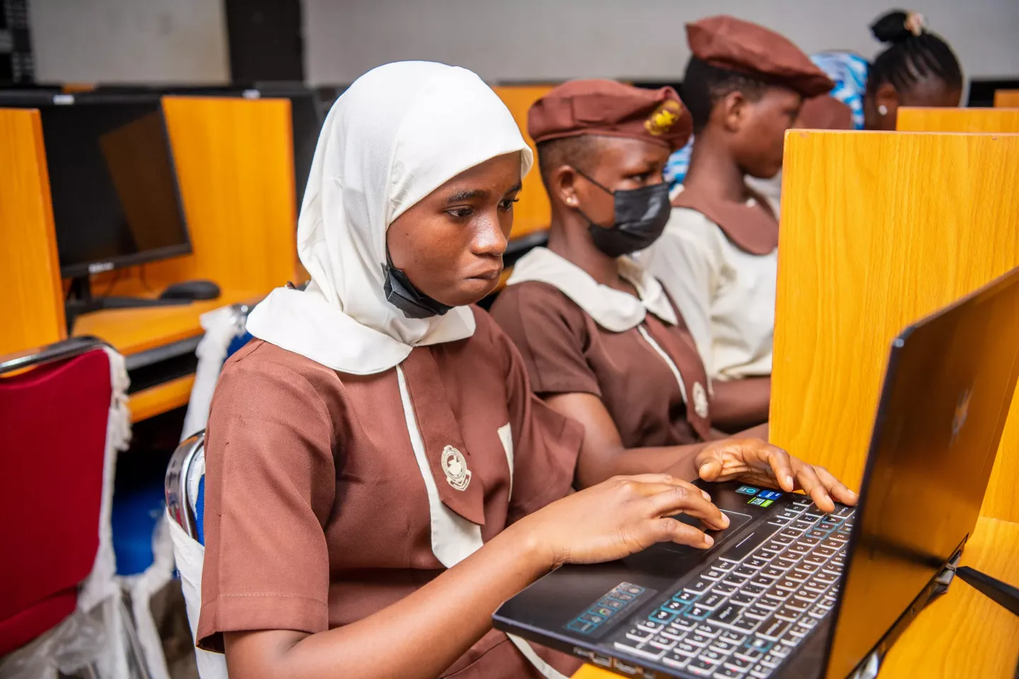 Rodiat using a computer in the school lab alongside her classmates.