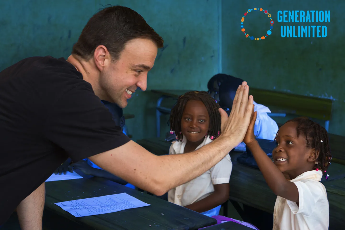 Picture of Kevin Frey Hi-fiving a young girl in a classroom