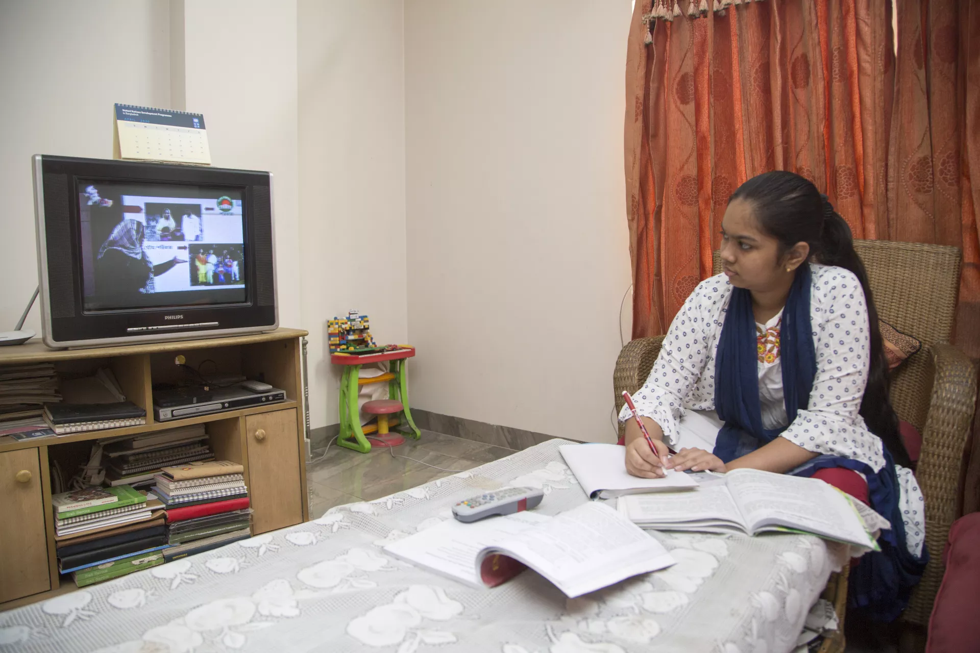 A young Bangladeshi girl is seen studying from home during the COVID-19 pandemic.