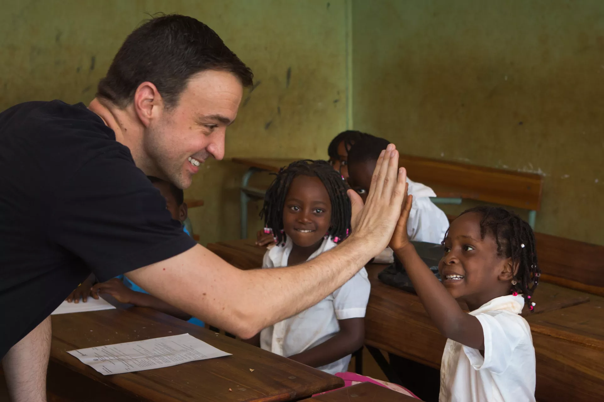 Kevin Frey seen hi5-ing a young girl in a classroom