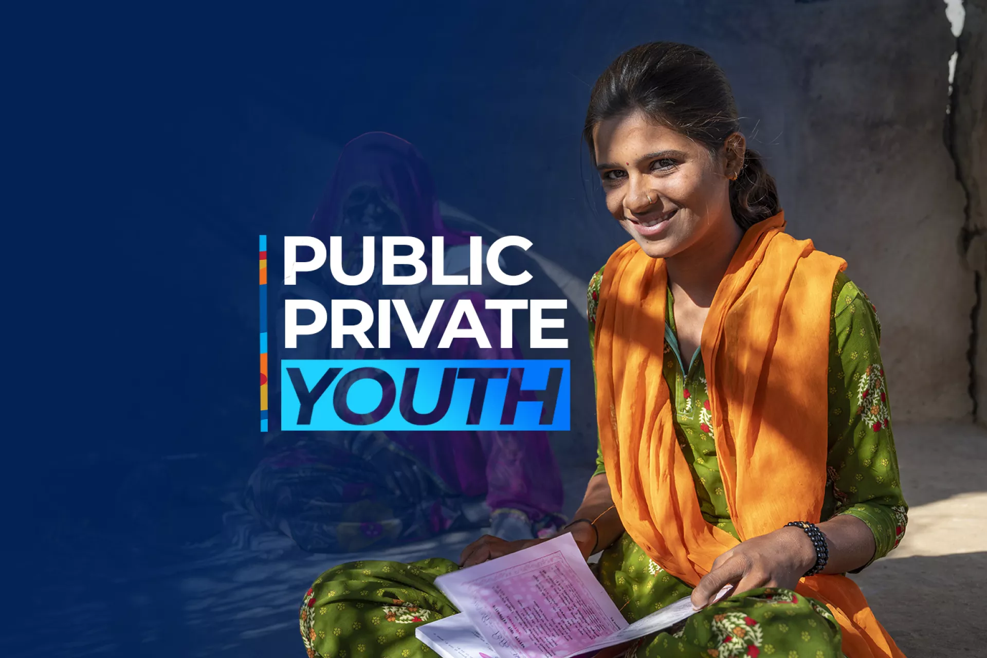 Image of a young girl smiling at the camera with a book on her lap