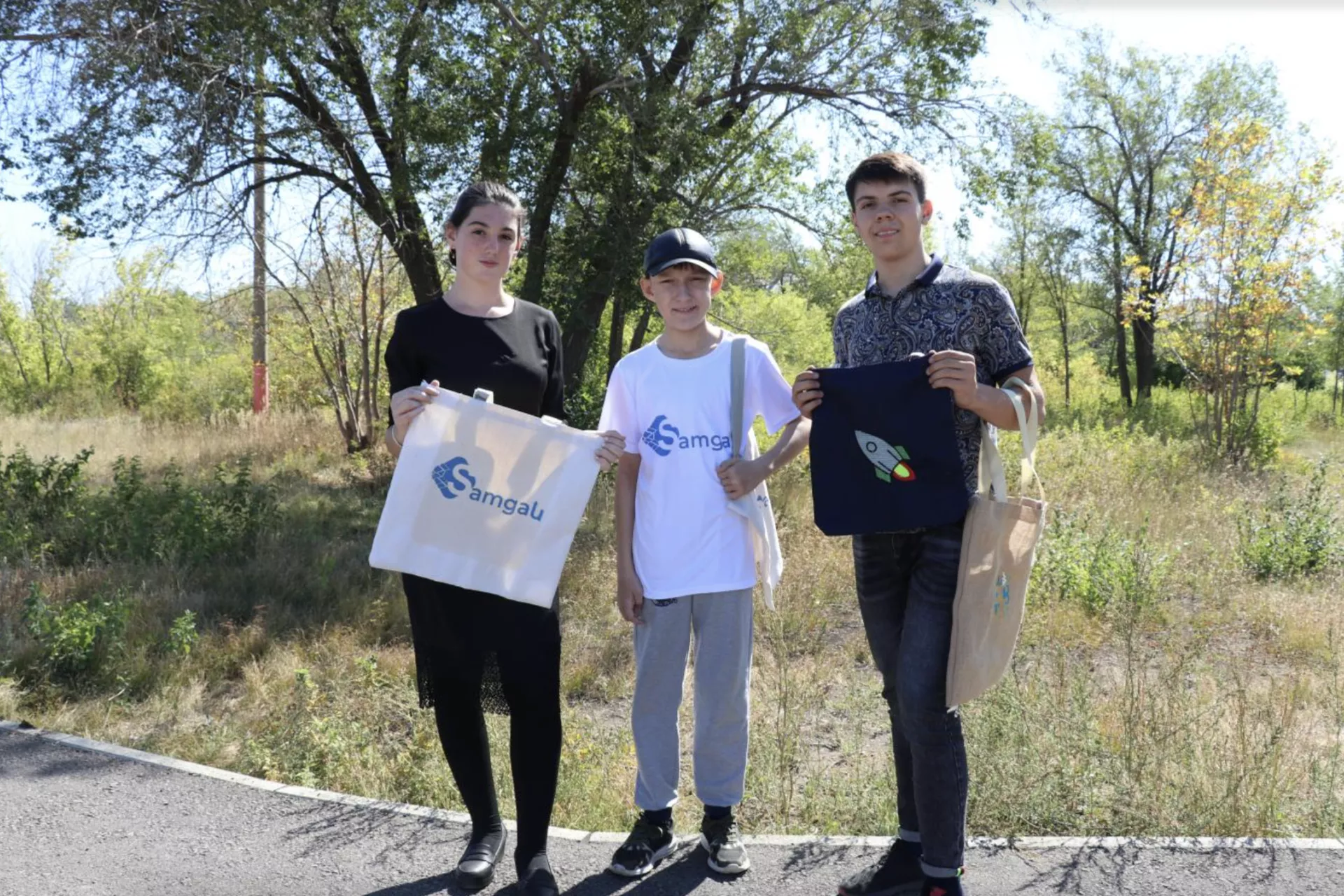 3 youngsters holding up their eco bags
