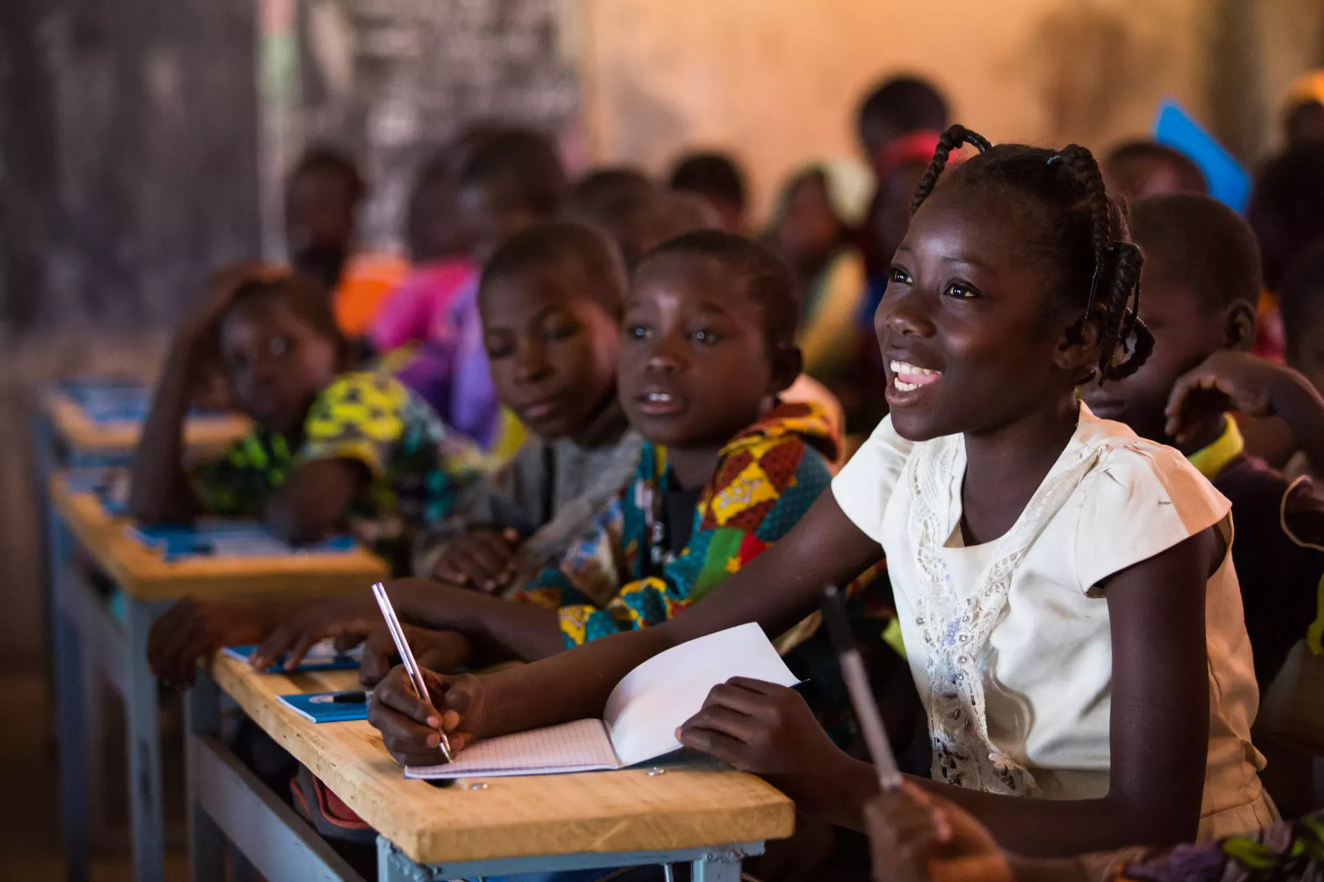 Nabyla (right), 13, attends class in Kaya, Burkina Faso, the town in which her family found refuge after being displaced.