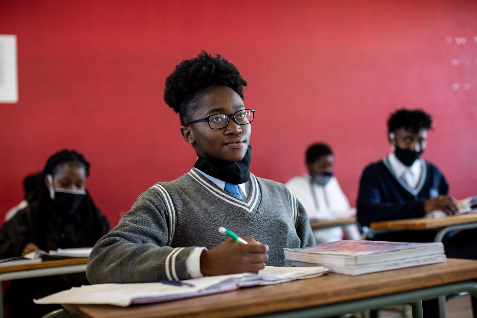A young girl from South Africa listening attentively while in a classroom