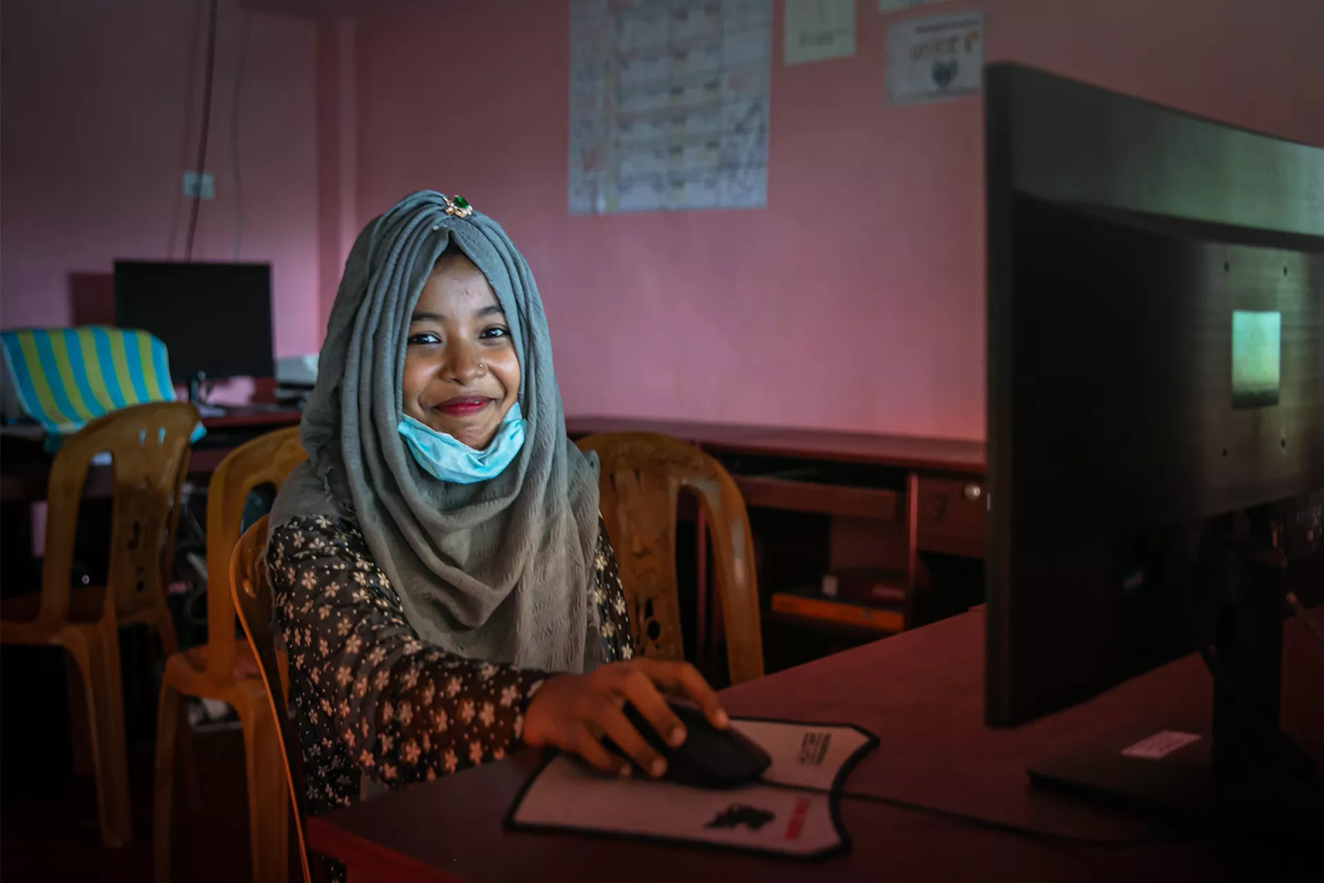A young girl from Bangladesh is operating a computer