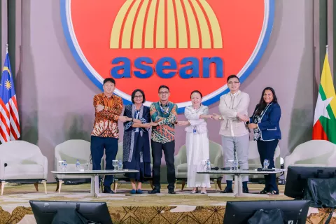 Representatives of organizations on stage holding hands