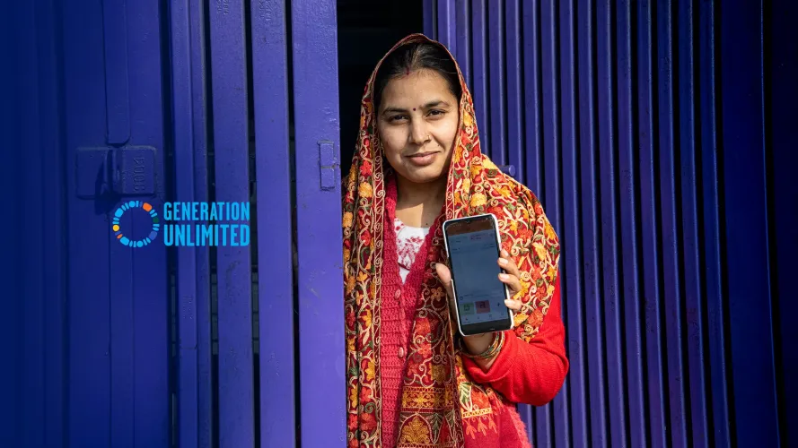 A young woman from India from the "Didi Ki Dukaan" initiative holding a smartphone upright