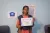 Anjaly Raveendran holds up a Passport to Earning certificate