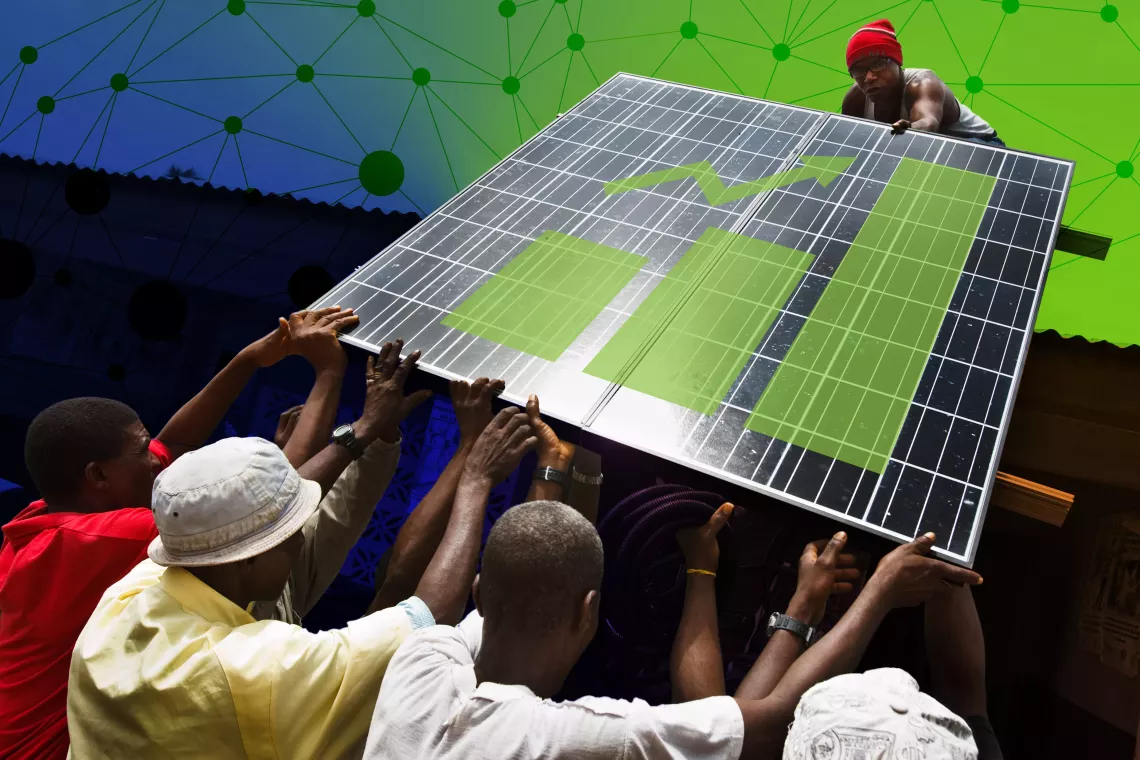 A group of men work together to move a solar panel onto a rooftop.