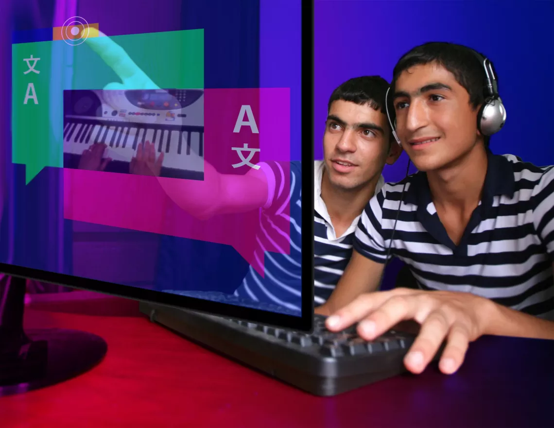 Two boys use a computer together in Azerbaijan.