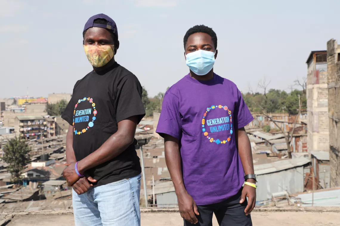 Two young boys  (Calvin shown in the left hand sight) in GenU T-shirts posing for a picture in an informal settlement in Kenya