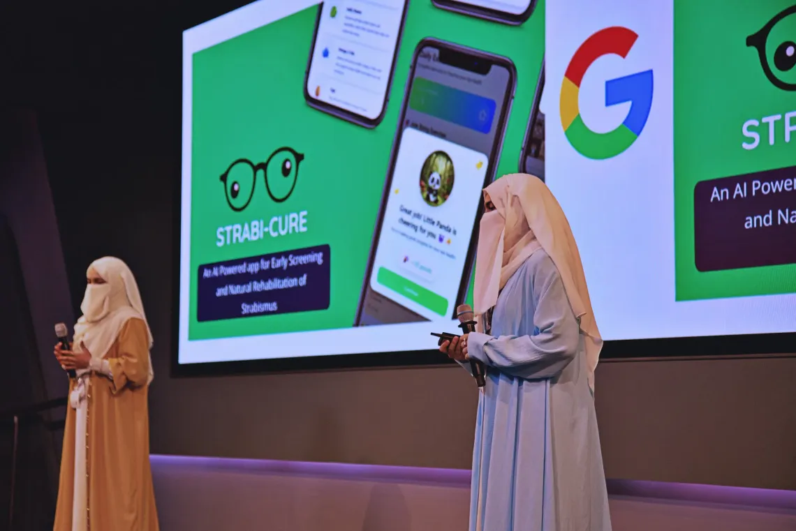 Young women leaders from India on stage presenting Strabi-Cure, an India-based venture using a standard smartphone camera to support earlier detection of strabismus in children.