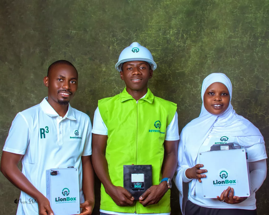 The Revnics team&mdash;two young men and a woman&mdash;pose together for a photo, each holding a box with their solution.