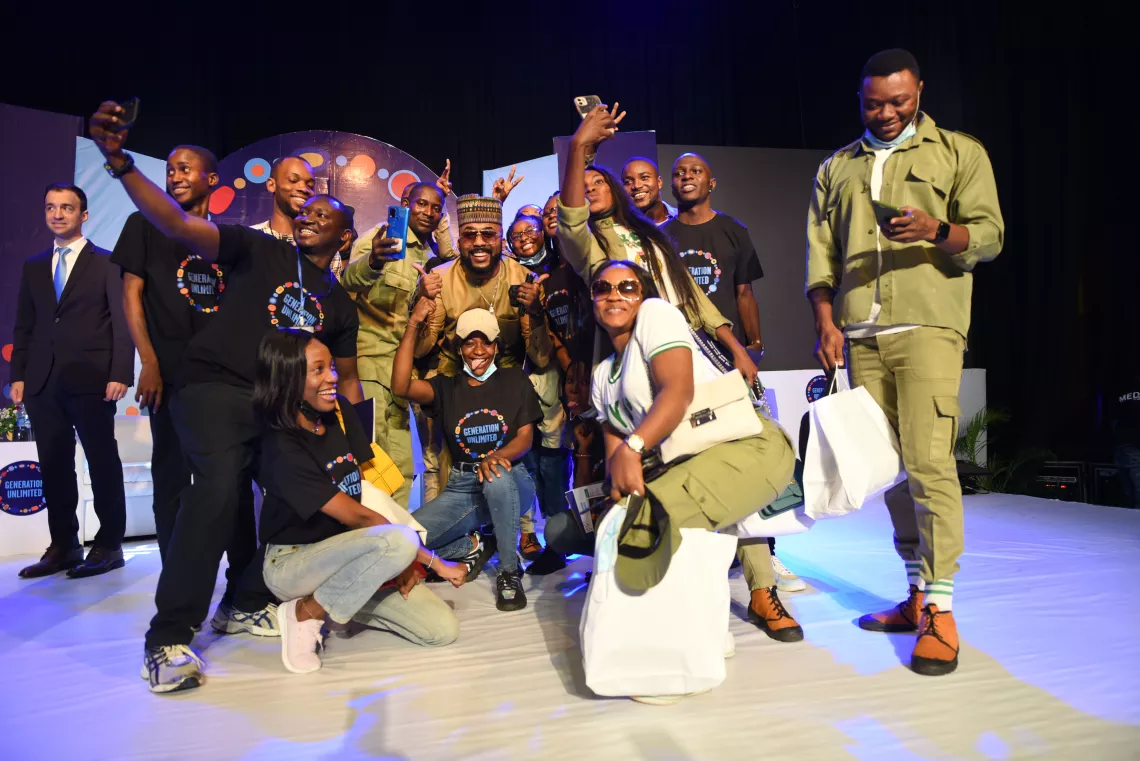 A group of young people on stage posing for a picture with Nigerian singer Banky W