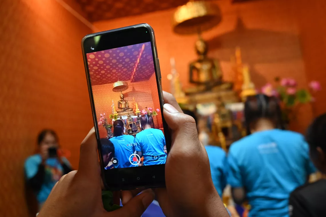 Young people and UNICEF volunteers use smartphones to film local culture and learn new skills.