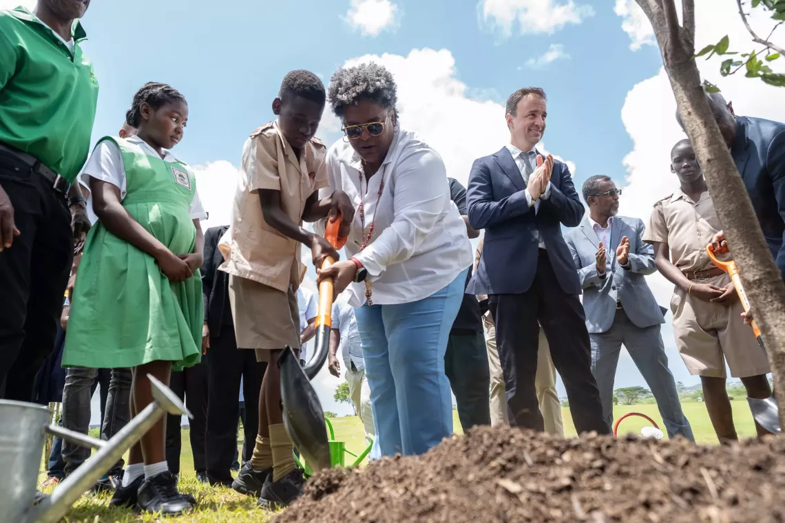 Prime Minister Mia Mottley and a young participant take part in a tree planting activity at the Green Rising launch in Barbados, alongside Generation Unlimited CEO Kevin Frey.
