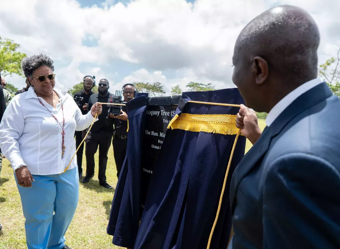 Prime Minister Mia Mottley and UNICEF Director of Programmes George Laryea-Adjei unveil a plaque at the Green Rising launch event in Barbados.