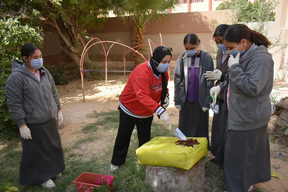 Enas Younis guides students through a hands-on activity on soil preparation as part of school-based climate action initiatives, helping them connect learning with real-life environmental action. Alexandria, Egypt