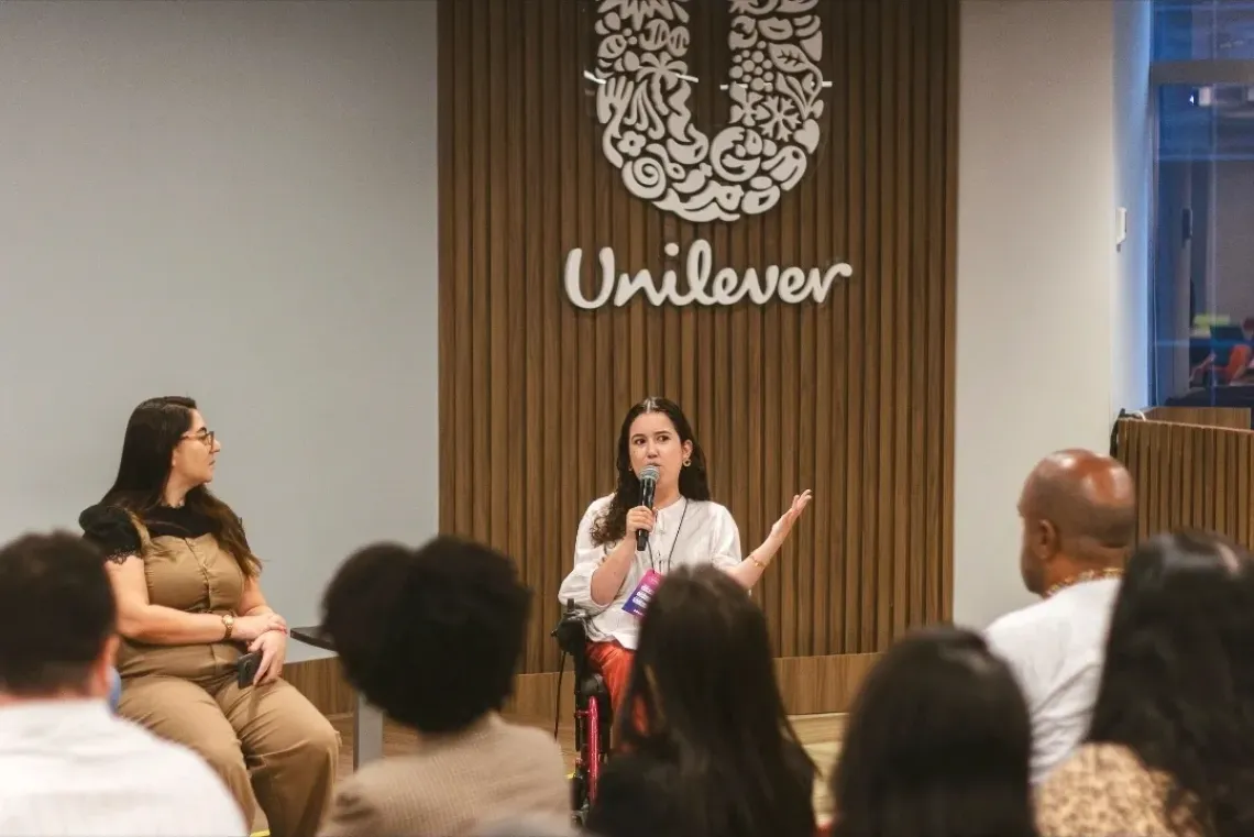 Lorena Fernandes presenting with a microphone at a gathering
