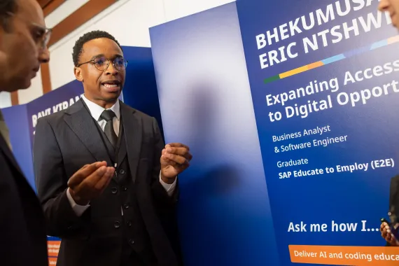 Bhekumusa "Eric" Ntshwenyai, a SAP Educate 2 Employ graduate, smiling in a brightly lit indoor setting.
